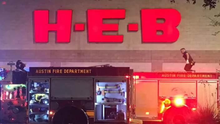 Austin fire news: H-E-B grocery store scene with emergency vehicles and dramatic lighting.