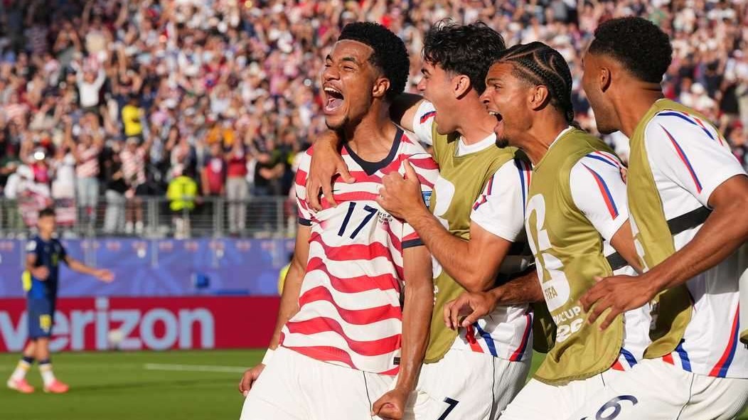 Smiling woman in USA soccer shirt discussing World Cup moments.