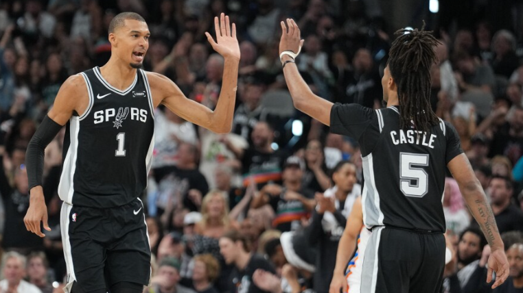 San Antonio sports team celebrating victory on basketball court.