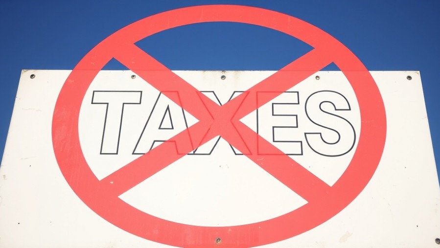 Sign reading 'TAXES' with no symbol, highlighting concerns over Texas property taxes.