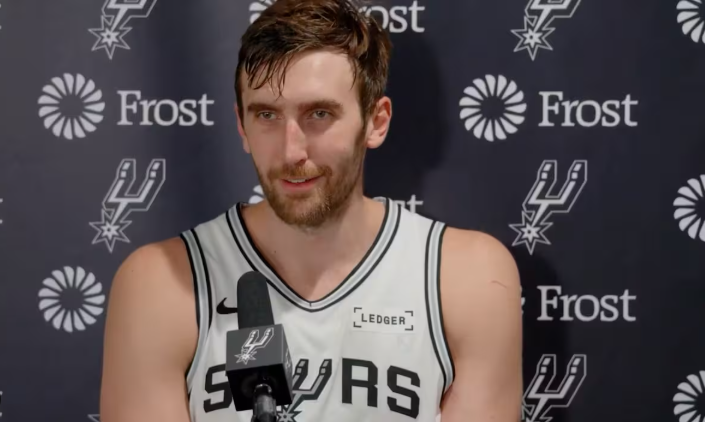 San Antonio Spurs player dunking during an intense game moment.
