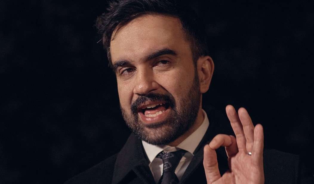 Energetic discussion at 'A New Era' podium with vibrant background, Mamdani's staff picks event.