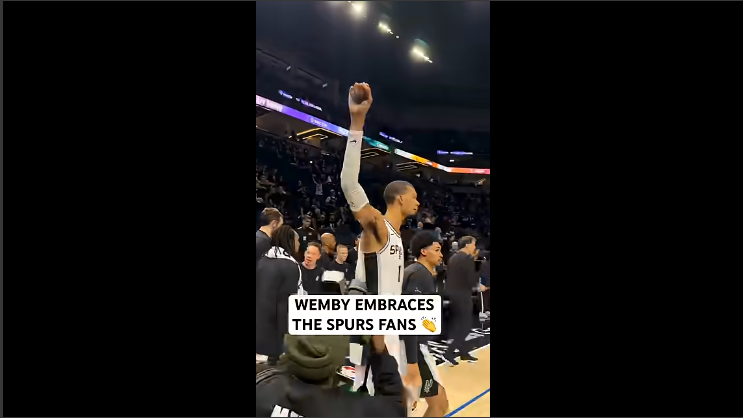 San Antonio Spurs fans celebrating with a player in the arena.