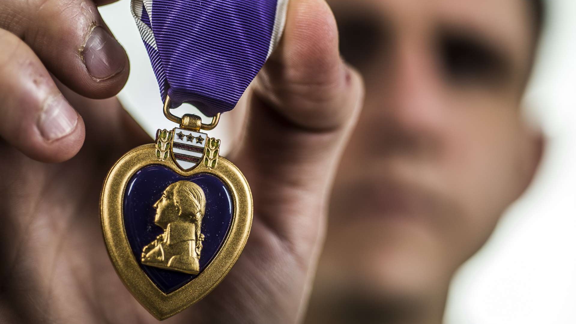 Veterans wearing Purple Heart medals at a medal ceremony honoring family legacy.