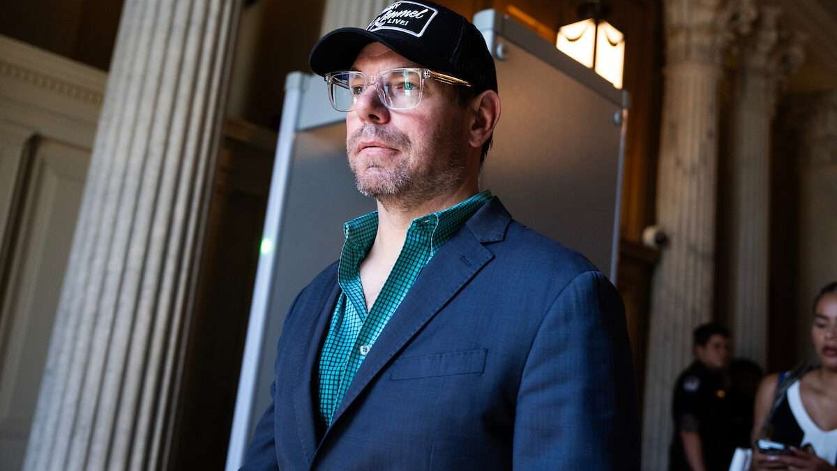 Confident man waving in farewell on stage during resignation.