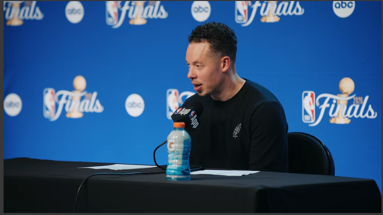 San Antonio Spurs players in a game, discussing strategy on the court.
