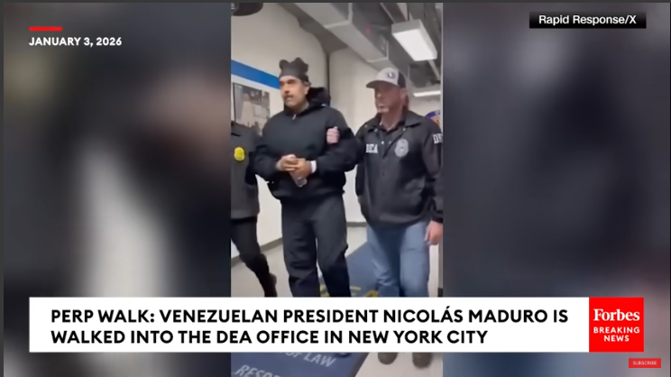 Law enforcement escorting individual in corridor, national news headline.