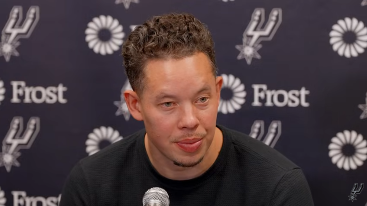 San Antonio Spurs game press conference focus with players in the background.