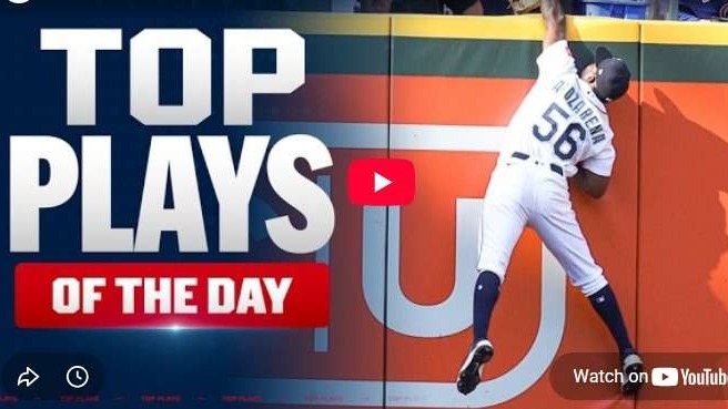 Baseball player catching a ball at the fence, sports action