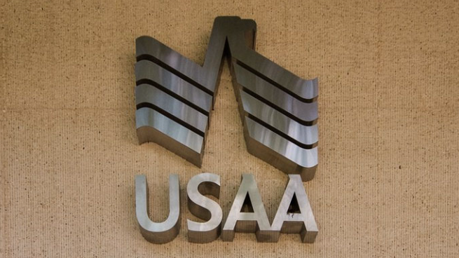 Parked cars near USAA sign in San Antonio, sunny day.