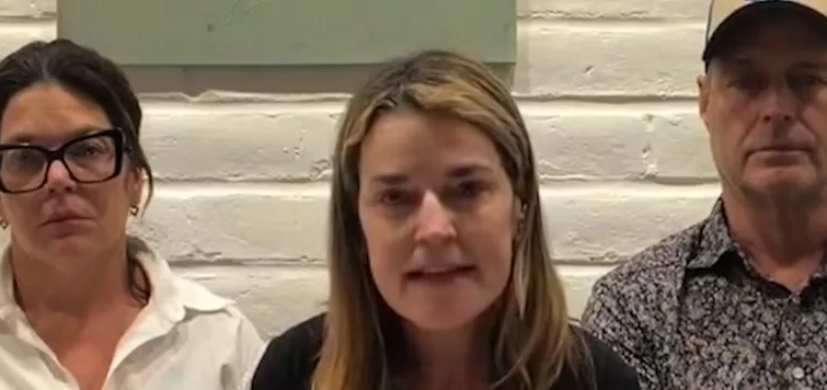 Two women smiling in colorful attire in a studio setting.