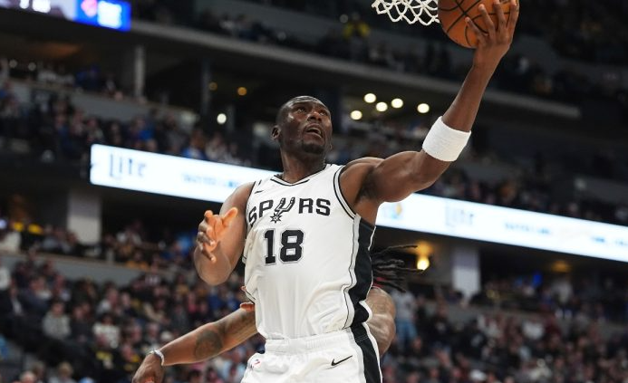 Bismack Biyombo at a breast cancer support event, smiling and engaging with attendees.