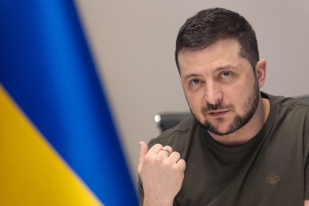 Political figure speaking with 'Peace' backdrop; Trump Zelenskyy meeting.