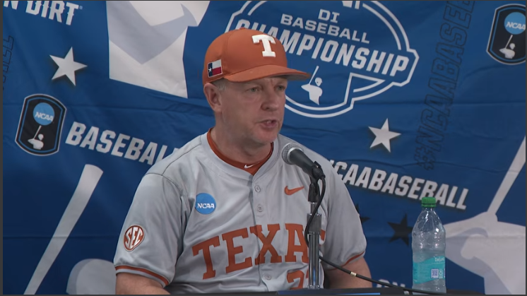 Austin Longhorns College World Series coach at press conference, serious expression.
