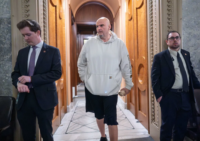 Bald US Senator John Fetterman in a black hoodie, delivering breaking US news.