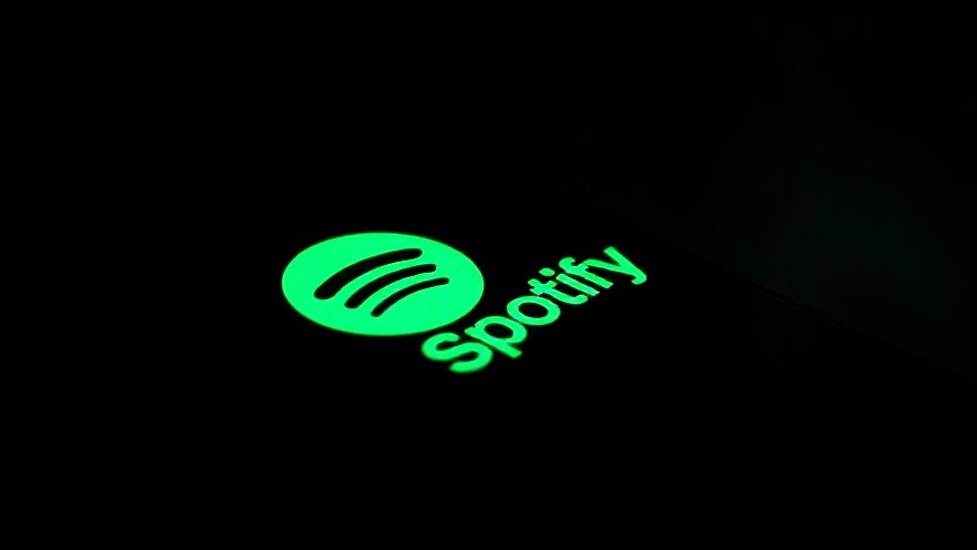 Close-up of a glowing Spotify logo on a smartphone, showcasing digital music evolution.