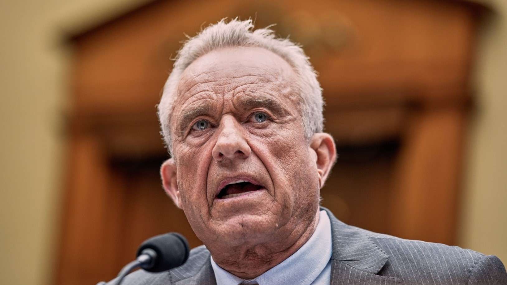 Mature man in suit discussing CDC vaccine recommendations outdoors.