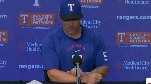 Baseball coach addressing media at sports conference in Dallas.