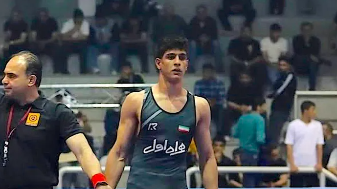 Iran Executes Teen Wrestling Star: Somber courtroom scene with young men.