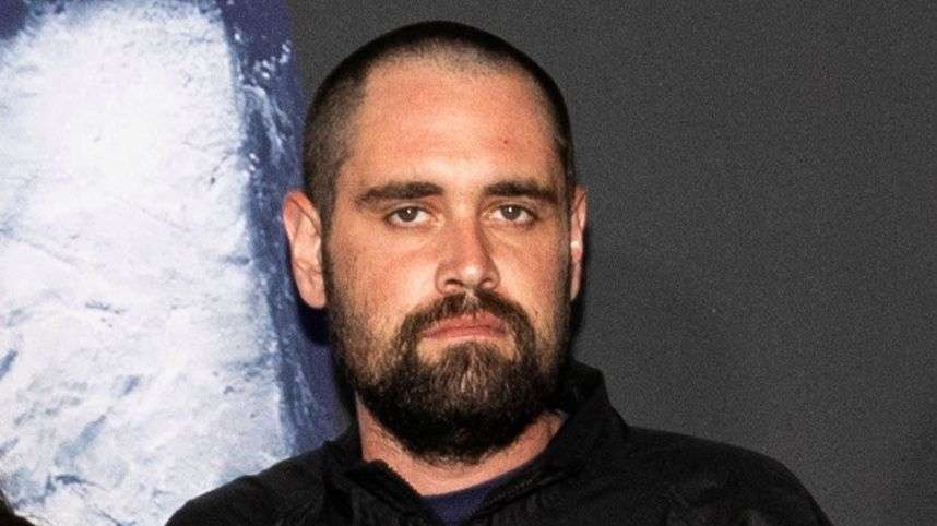 Older couple in black outfits at a film premiere event.