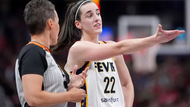 Woman in yellow blazer applauding at a sports event, WNBA officiating issues