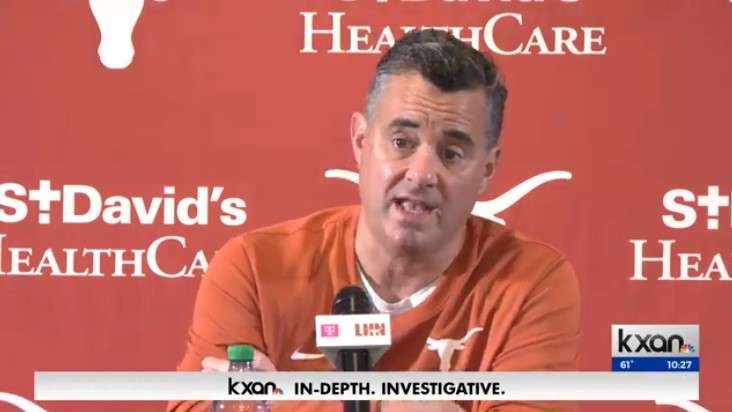 Middle-aged man discussing Texas men's basketball at a press conference.
