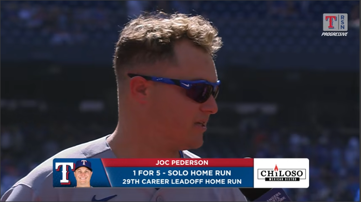 Baseball player speaking post-game interview at stadium.